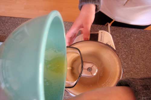 pouring olive oil mixture into food processor