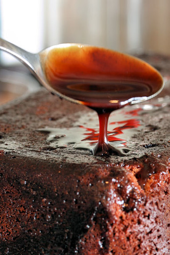 spooning chocolate syrup over cake 8775 R