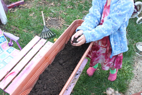 child filling a container garden