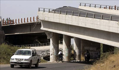 Un vehículo transita debajo de un puente que colapsó por Globovisión.