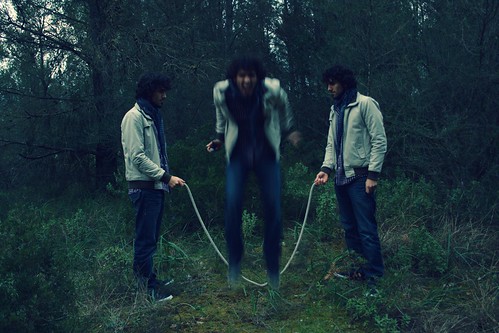 Jumping the jump rope in the forest with three identical clones 