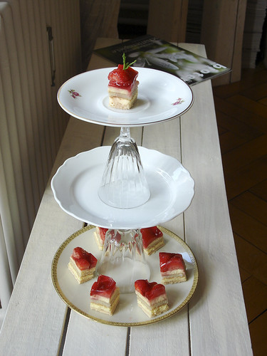 Etagere aus Teller und Gläser mit Erdbeertörtchen