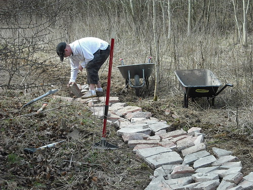 Arranging paving slabs as base material of a mountain bike track in Swindonl.