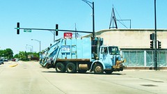 A City of Chicago Dept of Strets and Sanitation garbage truck turns the corner and heads east on West Higgins Avenue, Chicago Illinois. Wednsday, May 19th  2010.