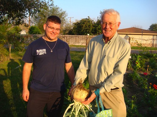 Dr. Alan Kirk (USDA-ARS) and a McAllen fireman admire a large turnip that was harvested from the garden. 