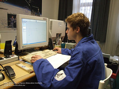 ein Jugendlicher, der in einem blauen Anzug, am Computer konstruiert.