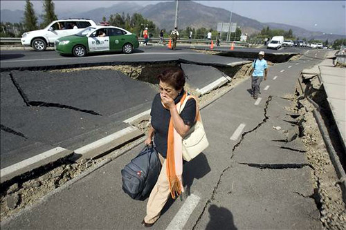 Una mujer camina junto a una carretera destruida tras el terremoto por Globovisión.