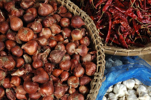 Basket of onions, chiles, garlic, market vendors goods, Dhaka, Bangladesh by Wonderlane