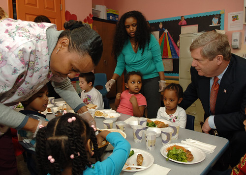 Agriculture Secretary Tom Vilsack helps students with their lunch at the Edward C. Mazique Parent Child Care Center in Washington, D.C. on Thursday, Feb. 4, 2010.  Secretary Vilsack is assisted by (L to R) Melkam Mekuria, Center Director and Freida Phiffer, Teacher Assistant. Agriculture Secretary Tom Vilsack and Health and Human Services (HHS) Secretary Kathleen Sebelius were at the facility to celebrate the one year anniversary of the Children’s Health Insurance Program Reauthorization Act (CHIPRA). Photo by Chris Smith