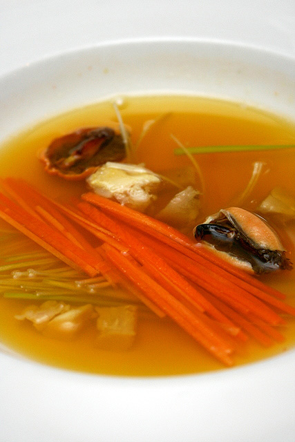 Saffron infused mussel consomme with low temperature braised patte jaune chicken and spring vegetable julienne