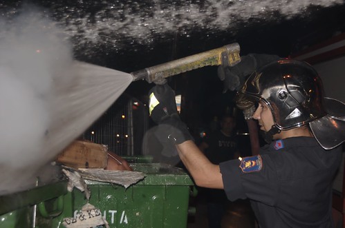 Fireman extinguishes trash cans set ablaze by football fans