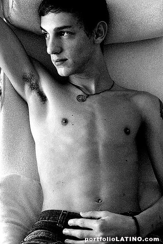 young shirtless latin hunk on the bed