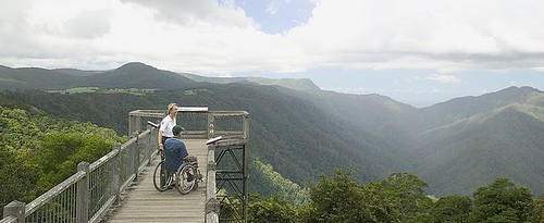 boardwalk lookout over incredible moutain forest view. 2 people on lookout, one in a wheelchair