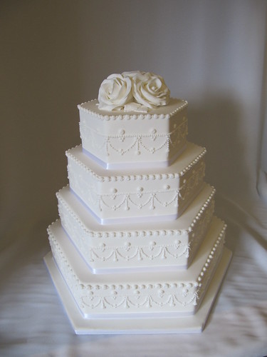 Hexagonal white iced with white lace details and sugar roses