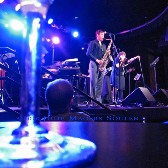 Blue lights on a small stage, martini glass glowing, and an evening of jazz.