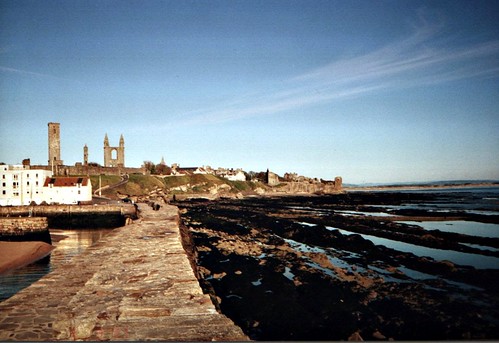 The harbor and pier.

Students who attend chapel, and those who care to join them, walk out in their scarlet flannel gowns along the lower level of the pier, to the left in the picture. In my day the men walked back along the higher part of the pier. There was a tradition that when women were admitted to the University in 1889 (St. Andrews was the first in Scotland to admit them), the men tossed their trenchards (to Americans, mortar-boards) into the sea. Recently the Alumni Journal denounced this tale as a myth. It still makes sense to me, because in the 1930's the women (who slightly outnumbered the men) wore trenchards, but the men didn't. The bejantines (first year women) wore yellow tassels, the semis red and the seniors black, if I remember correctly.