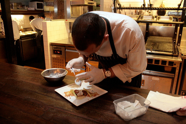 Chef Damon Amos scooping the gunpowdered mascarpone onto the dessert