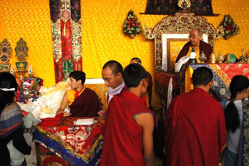 Sakya Lamas at the conclusion of the Sakya Lamdre, HH Dagchen Rinpoche and grandson, while monks, practicioners, well wishers, and friends pass by for the final blessing, long life, Tharlam Monastery, Nepal by Wonderlane