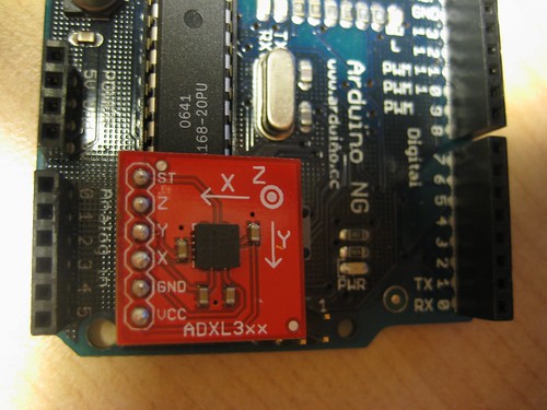 [Analog Devices' ADXL330 accelerometer on a Sparkfun breakout board next to the pins on an Arduino NG to which the board connects.]