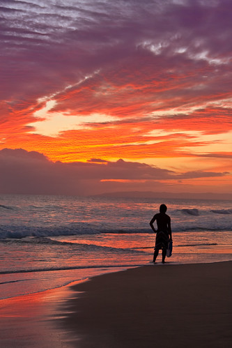 hawaii beaches at sunset. Surfer dude on Hawaiian beach
