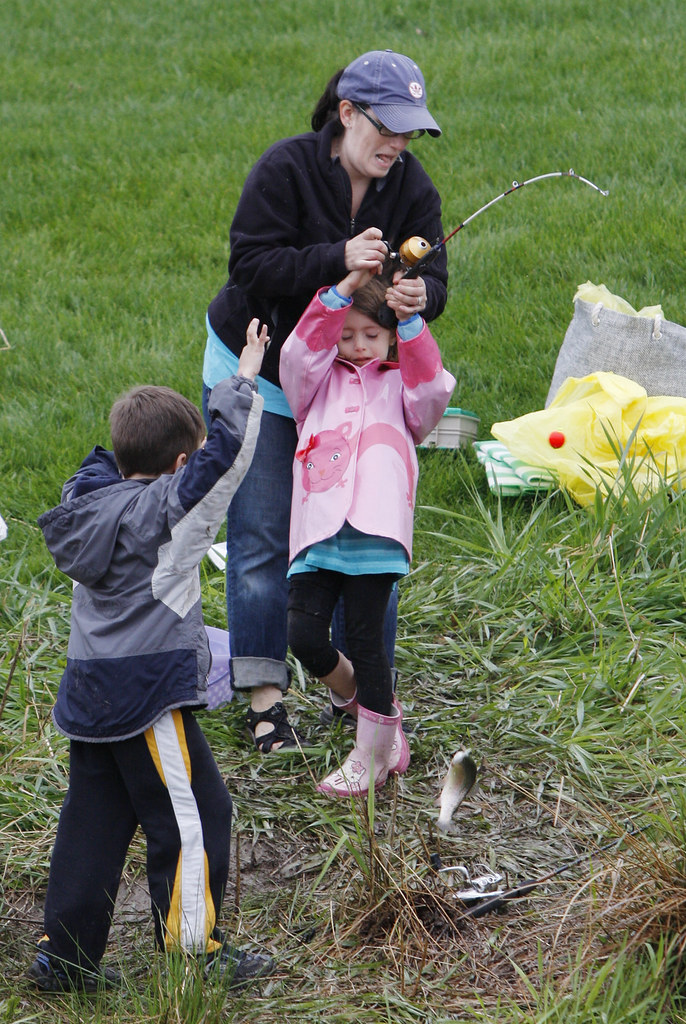 May 8, 2010 - Cristina Fox from Florence helps her daughter Gabriella Fox, 6, reel in a fish at the Family Fishing Event hosted by The U.S Fish and Wildlife Service in Hadley. Trevor Maslowski, 6, from Leeds cheers them on as they bring it in. 