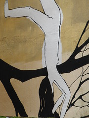 pintada mujer desnuda haciendo el pino en rama de árbol