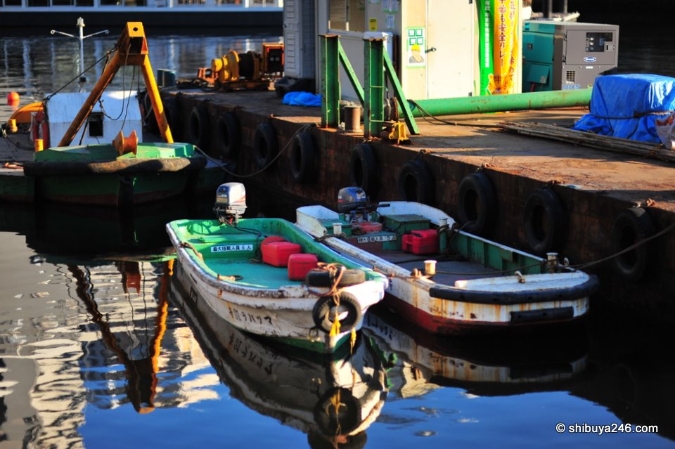 Some colorful boats tethered to the barge, ready for some time of work in the area.