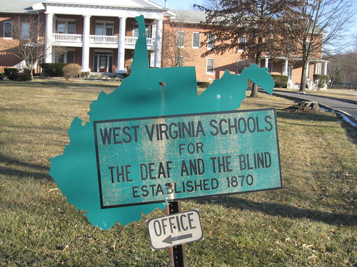 A sign shaped like West Virginia that reads: West Virginia Schools for the Deaf and Blind Established 1870
