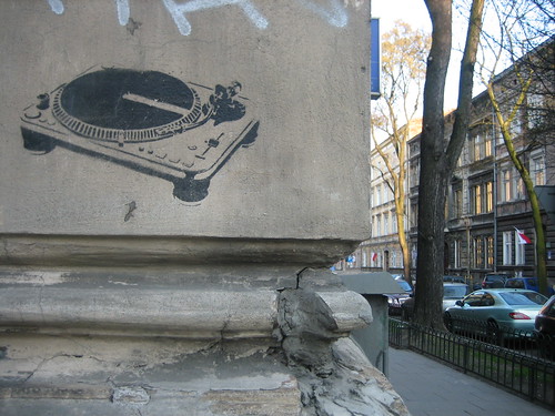 graffiti of a turntable, painted onto the side of a grey concrete building ornamentation