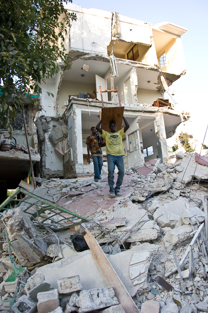 Men salvage furniture from an earthquake-damaged house in Port-au-Prince 
