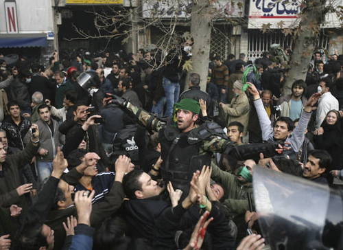 Polizist mit grünem Schal bei Protesten