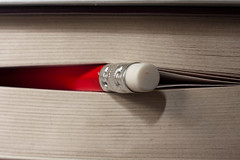 Macro of red HB pencil peeking through a book