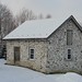 stone barn in snow