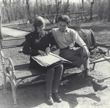 Young woman and man braille reading on park bench