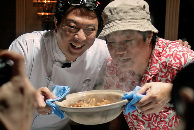 Executive Chef Eric Teo and KF Seetoh holding up the very hot claypot of sesame-ginger chicken