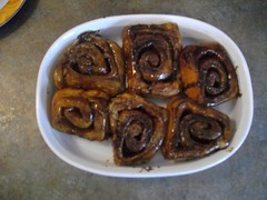 Cinnamon buns are flipped to reveal their glazy goodness