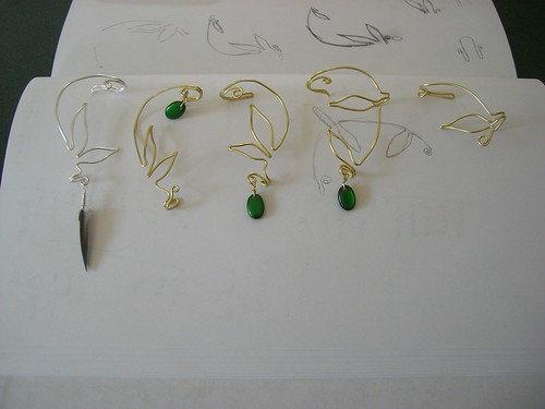 Ear cuffs in a row. Silver with feather; brass with beads (and without).