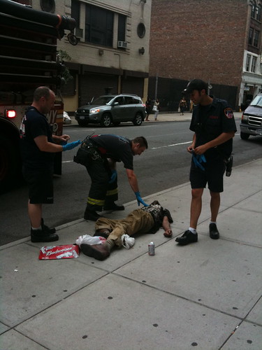 EMTs assisting man lying on the ground