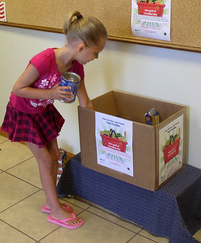 Mackayla Wallin, age five, makes her contribution to feed the hungry in Grant, Neb. at the recent “Feds, Farmers, and Friends Feed Families” food drive.