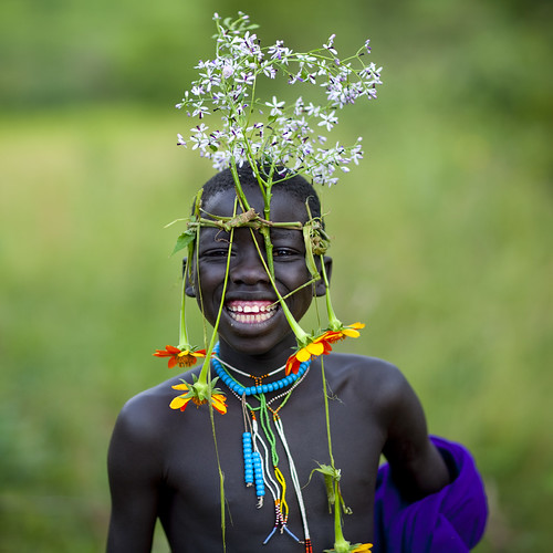 Surma tribe kid with flowers decoration - Omo Ethiopia by Eric Lafforgue