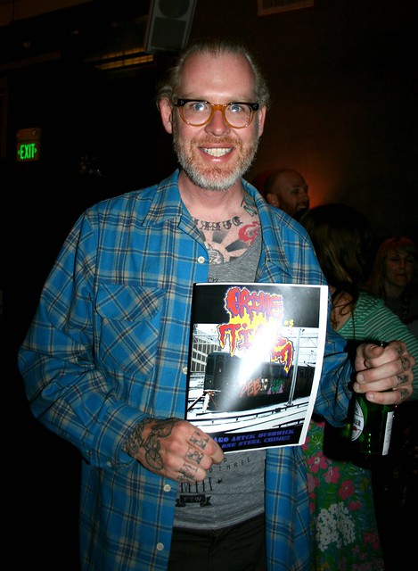 Mike Giant with a copy of Chicago's Grime Time magazine. At "Everyday", a show of artwork by California tattoo artists at 111 Minna Gallery, SF