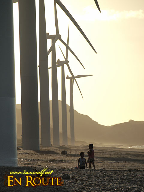 Kids playing beside the windmills late afternoon