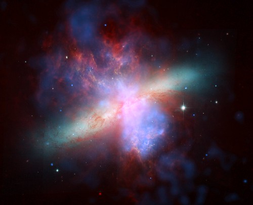 Stunning View of Starburst Galaxy (NASA, Chandra, 04/24/06) [EXPLORED] <i>Editors Note: This is an archive image from 2006.</i>  Images from three of NASAs Great Observatories were combined to create this spectacular, multiwavelength view of the starburst galaxy M82. Optical light from stars (yellow-green/Hubble Space Telescope) shows the disk of a modest-sized, apparently normal galaxy.  Another Hubble observation designed to image 10,000 degree Celsius hydrogen gas (orange) reveals a startlingly different picture of matter blasting out of the galaxy. The Spitzer Space Telescope infrared image (red) shows that cool gas and dust are also being ejected. Chandras X-ray image (blue) reveals gas that has been heated to millions of degrees by the violent outflow. The eruption can be traced back to the central regions of the galaxy where stars are forming at a furious rate, some 10 times faster than in the Milky Way Galaxy.  Many of these newly formed stars are very massive and race through their evolution to explode as supernovas. Vigorous mass loss from these stars before they explode, and the heat generated by the supernovas drive the gas out of the galaxy at millions of miles per hour. It is thought that the expulsion of matter from a galaxy during bursts of star formation is one of the main ways of spreading elements like carbon and oxygen throughout the universe.  The burst of star formation in M82 is thought to have been initiated by shock waves generated in a close encounter with a large nearby galaxy, M81, about 100 million years ago. These shock waves triggered the collapse of giant clouds of dust and gas in M82. In another 100 million years or so, most of the gas and dust will have been used to form stars, or blown out of the galaxy, so the starburst will subside.  Credits: X-ray: NASA/CXC/JHU/D.Strickland; Optical: NASA/ESA/STScI/AURA/The Hubble Heritage Team; IR: NASA/JPL-Caltech/Univ. of AZ/C. Engelbracht  Read entire caption/view more images: <a href="http://chandra.harvard.edu/photo/2006/m82/" rel="nofollow">chandra.harvard.edu/photo/2006/m82/</a>  Caption credit: Harvard-Smithsonian Center for Astrophysics  Read more about Chandra: <a href="http://www.nasa.gov/chandra" rel="nofollow">www.nasa.gov/chandra</a>  p.s. You can see all of our Chandra photos in the Chandra Group in Flickr at: <a href="http://www.flickr.com/groups/chandranasa/">www.flickr.com/groups/chandranasa/</a>  Wed love to have you as a member!