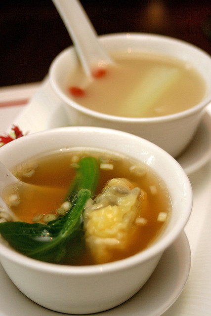 Hong Kong style minced pork and shrimp dumpling soup with choy sum (foreground) and Double-boiled fish broth with pak choy, fish maw and tofu