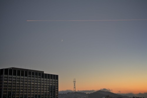 An airplane passes Sutro Tower