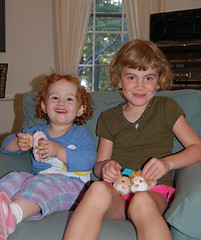 grinning Speck and cousin S, together in an arm chair, with Zuzu pets in hand