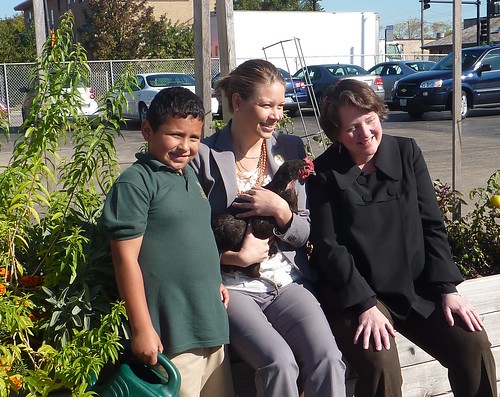 Deputy Secretary Merrigan and Sarah Elizabeth Ippel in the garden at the Academy of Global citizenship with one of their students and a chicken from the school’s chicken coop.