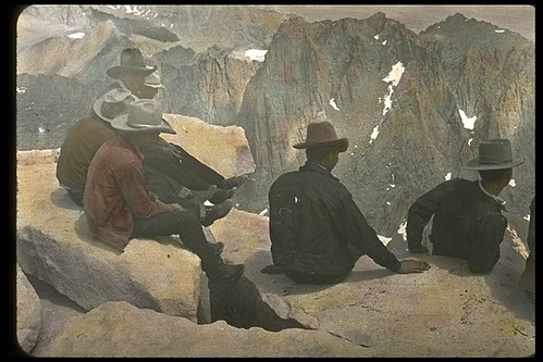 Packers enjoying the view from the top of Mt. Whitney, 1932. Hand tinted photograph.