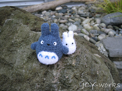 chibi and chu Totoro climbing past a rocky mountain.