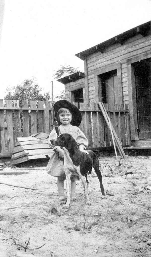 Portrait of girl with toy gun and dog